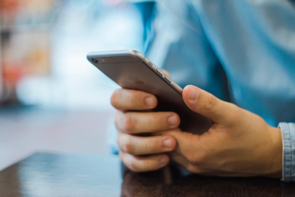 Handen die een bericht typen op een smartphone