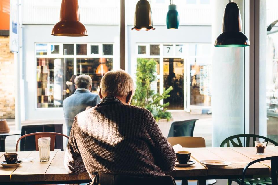 Klant aan een tafel in een lichte koffiezaak